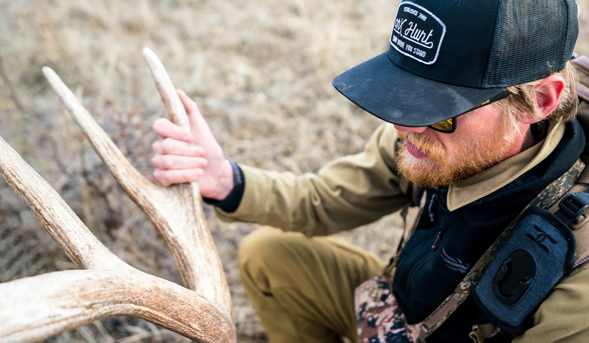 Montana hunting photographer and onX Ambassador Steven Drake with an elk shed found while shed hunting.