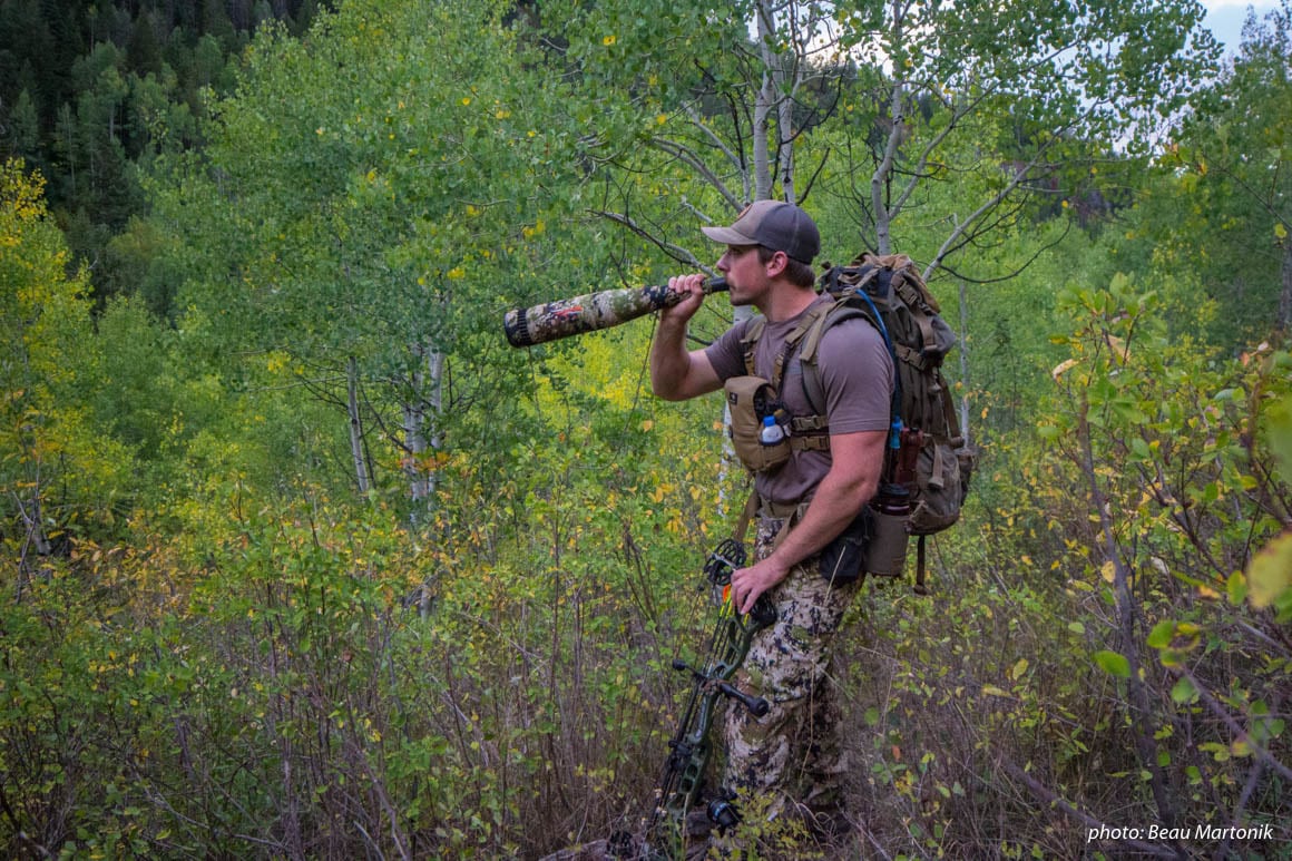 Man bugling for elk while hunting in the mountains.