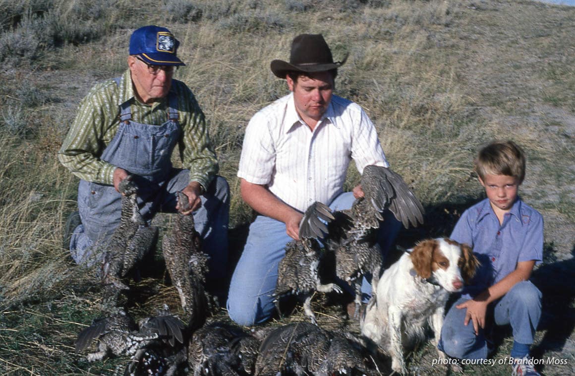 Three generations of Montana hunters with Brittany spaniel and sage grouse, upland hunting.