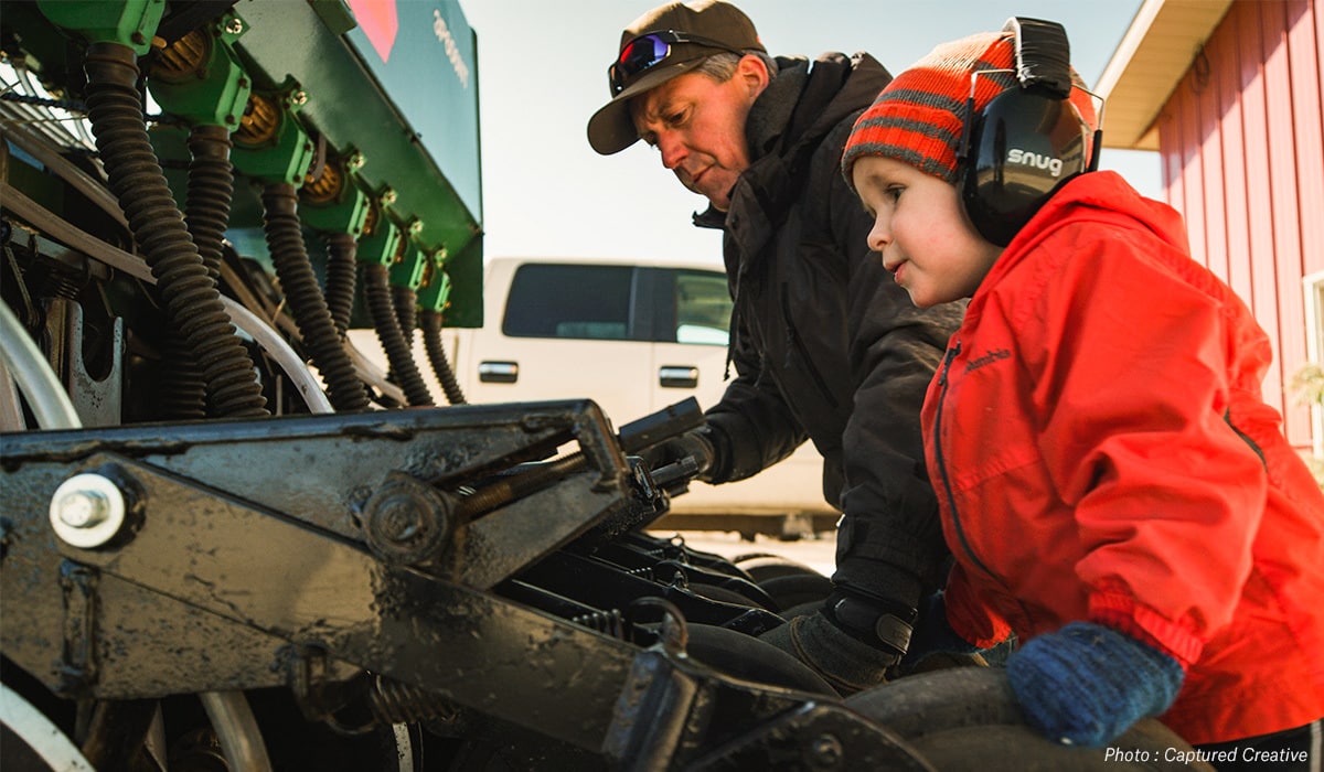 Taylor Kollman's father and son inspecting equipment on their Minnesota hunting property.