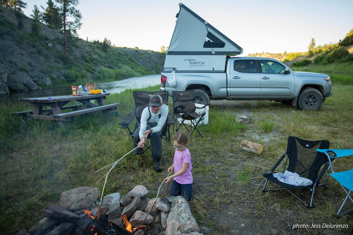 Father and daughter at campfire while truck camping in Montana.