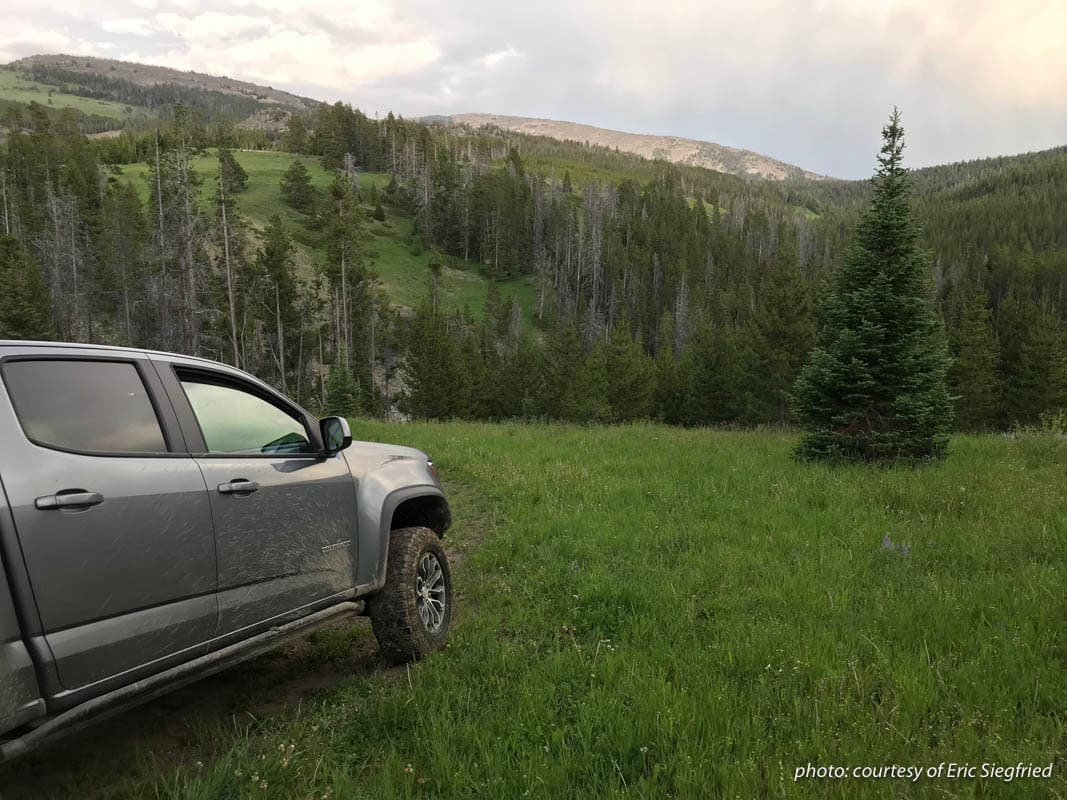 Muddy truck parked near the mountains of Montana.