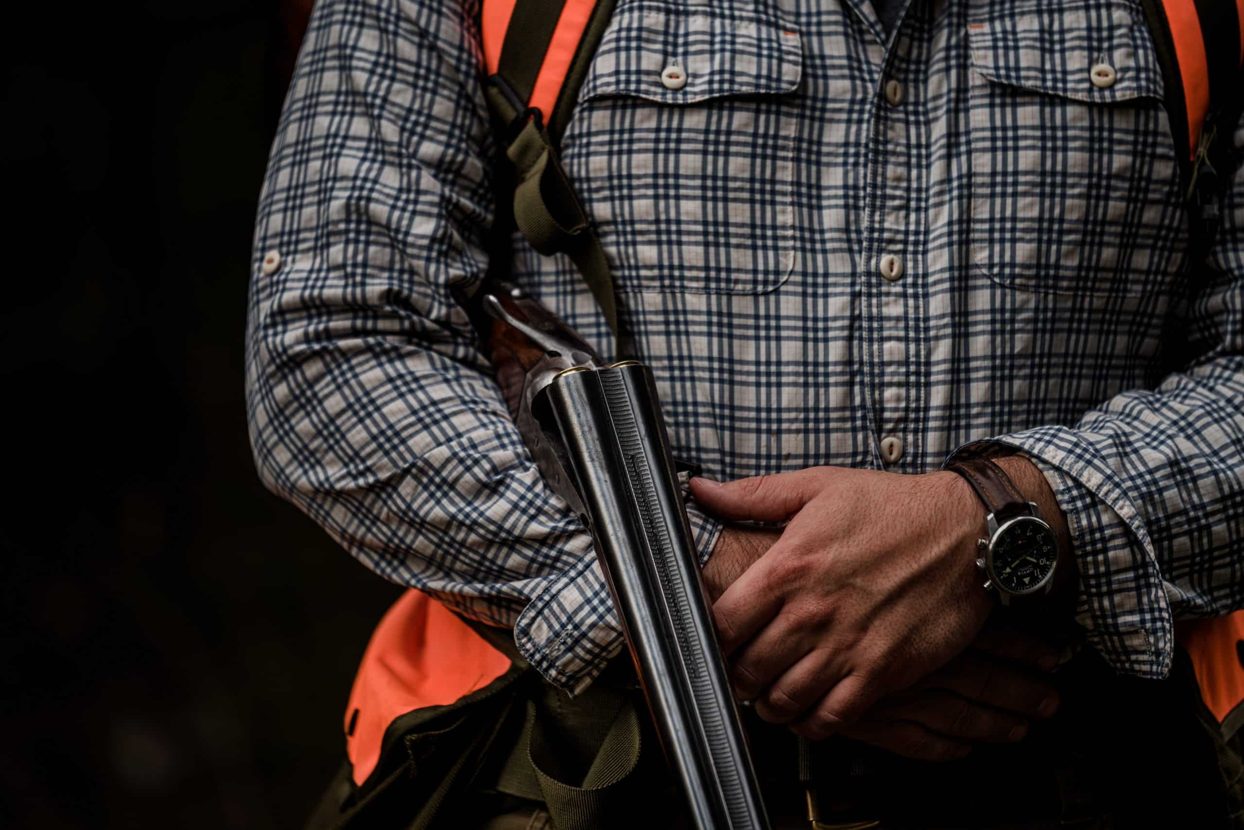 A hunter holds a side-by-side shotgun while grouse hunting in northwest Montana.