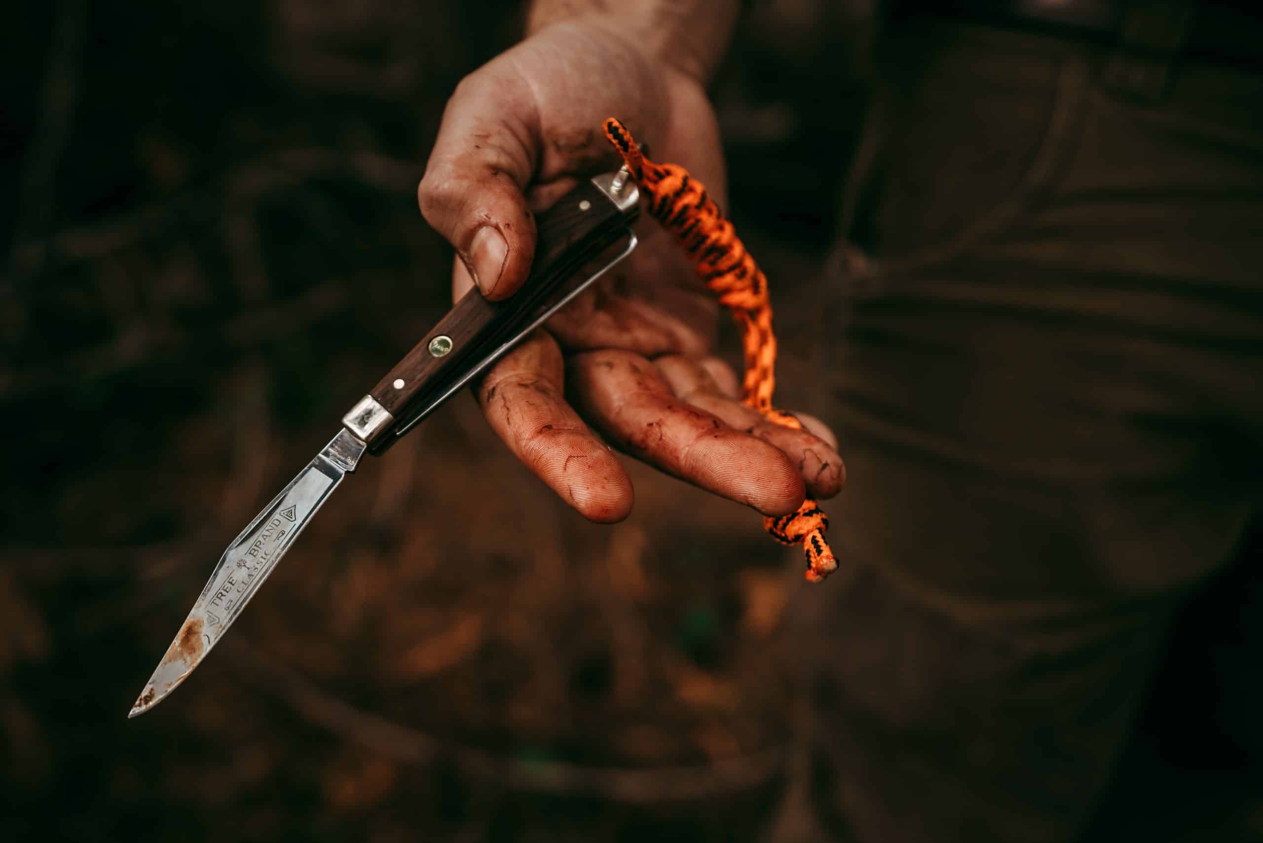 A hunter holds a knife after cleaning grouse.