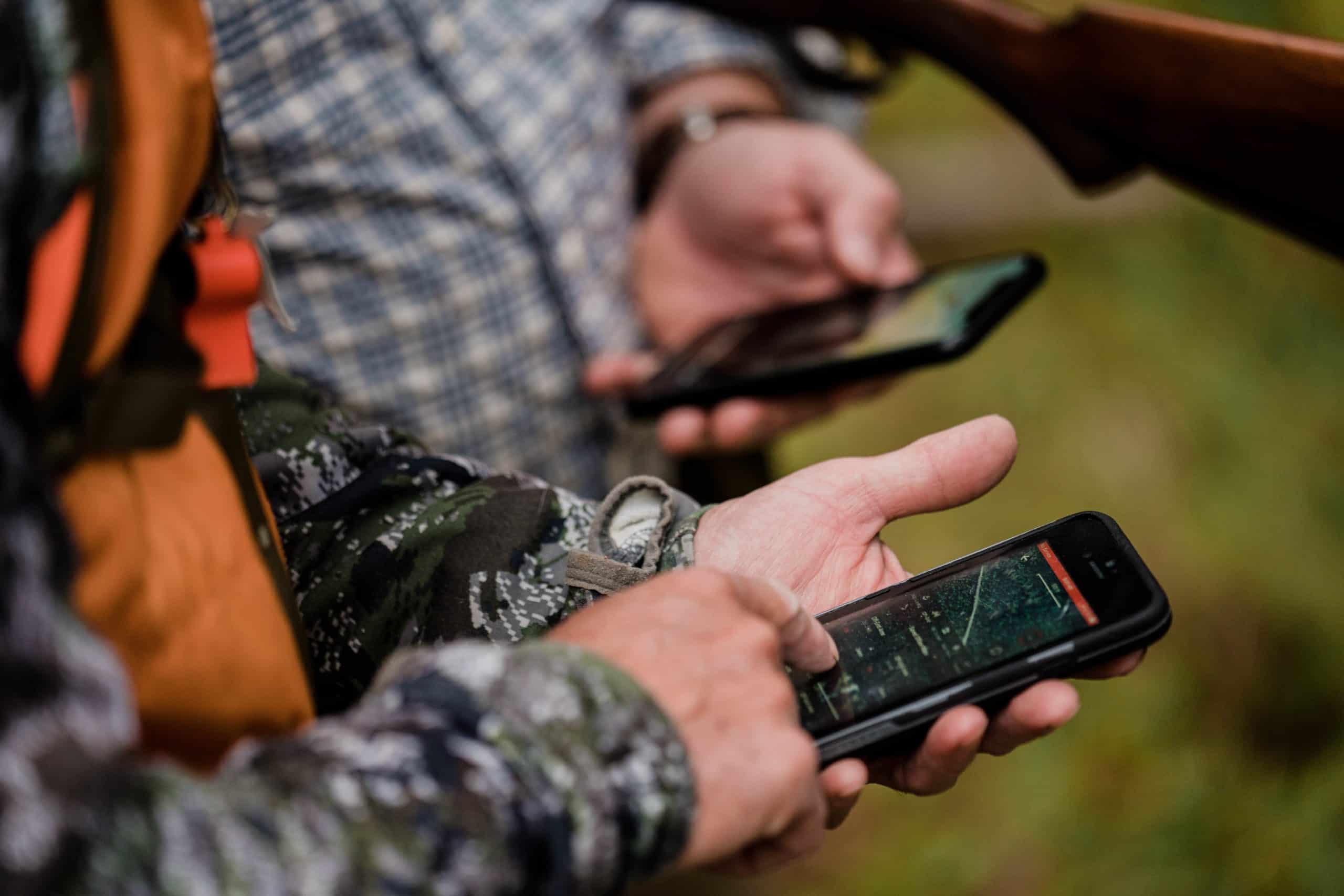 Two hunters use the onX Hunt App to decide which direction to go.