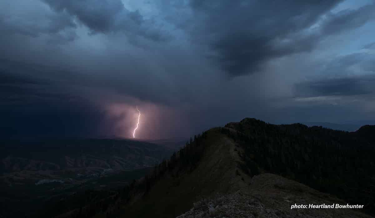 Lightning striking mountain during thunderstorm.