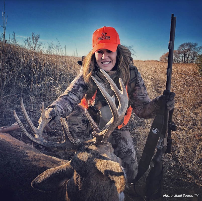 Woman hunter posing with deer shot during hunting season.
