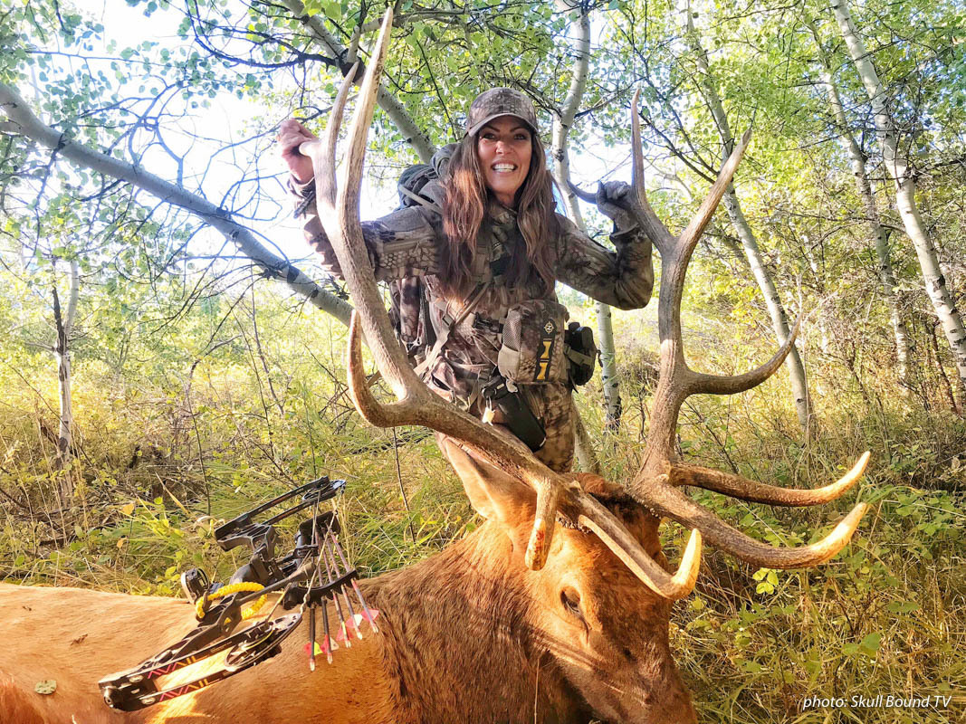 Women bowhunting with elk she shot.
