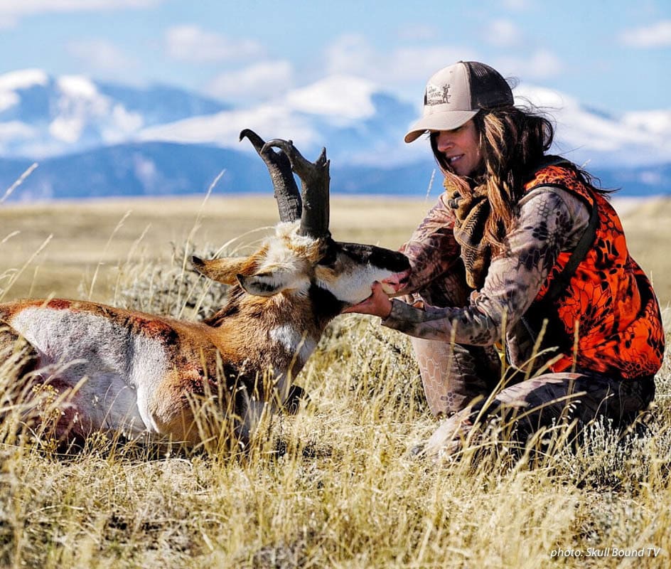 Female hunter hunting in the plains with antelope she shot.