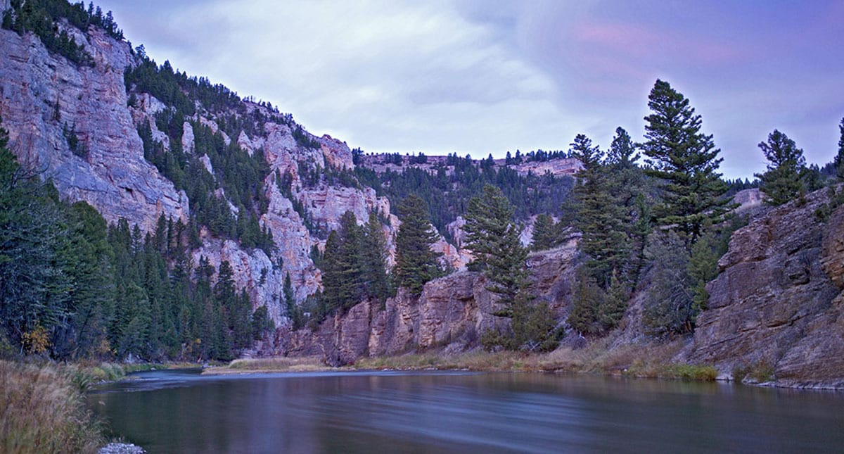 Image of the Smith River in Montana, with craggy cliffs, river and sky at sunrise.