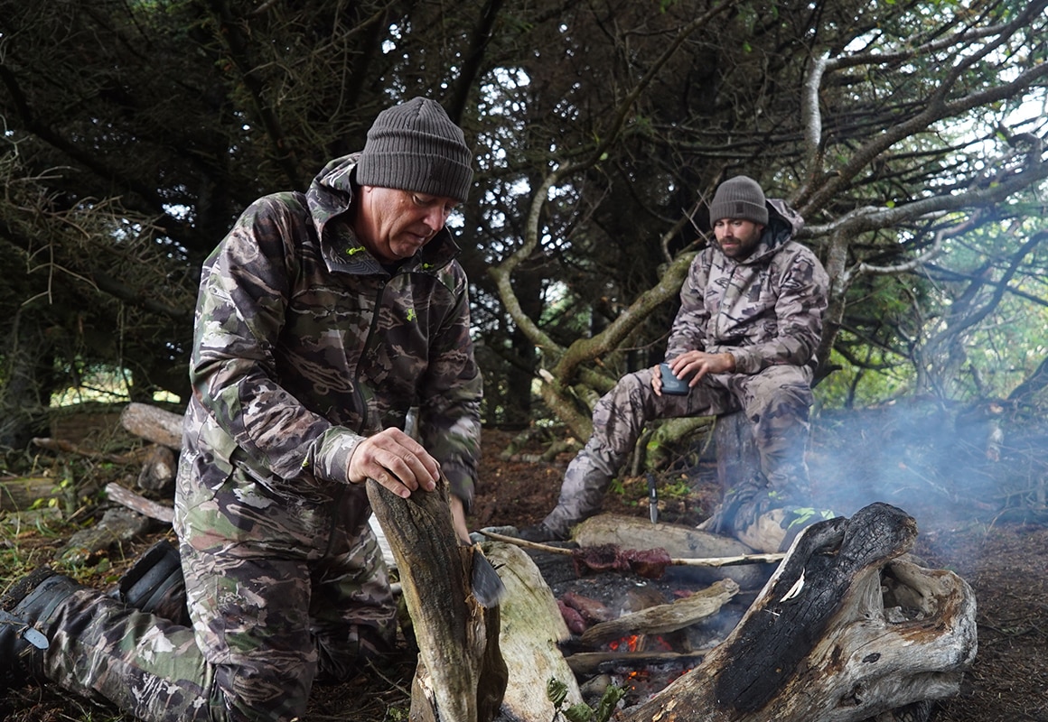 onX pro-staffer Remi Warren & son cooking sitka blacktail venison on a hot rock camp fire.