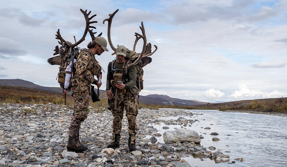Two hunters pack out caribou after a successful hunt in Alaska.