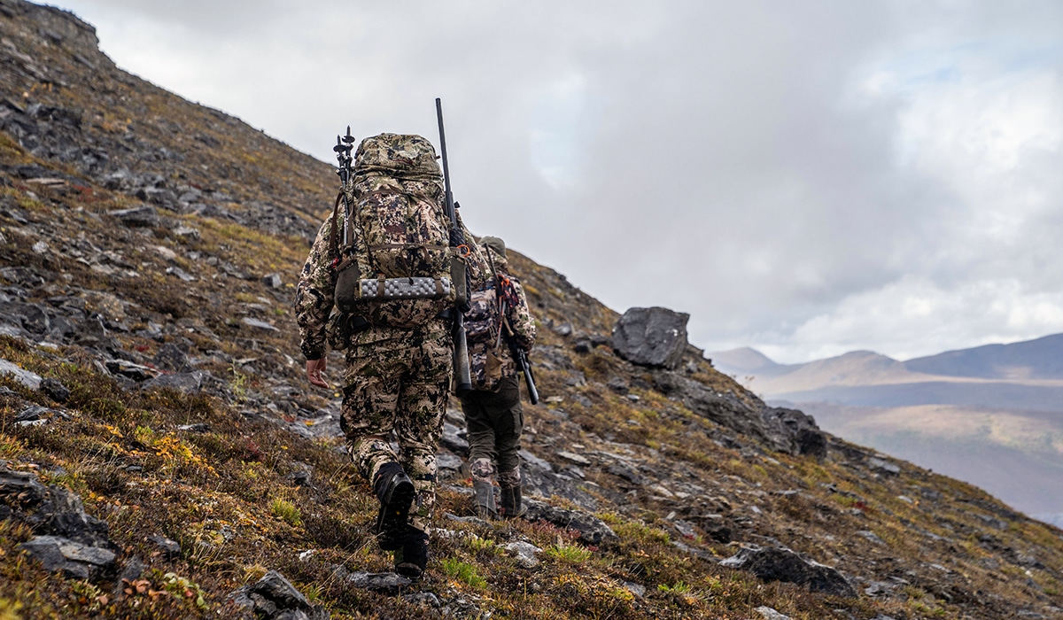 Two hunters hiking across mountains in Alaska as they hunt for caribou.