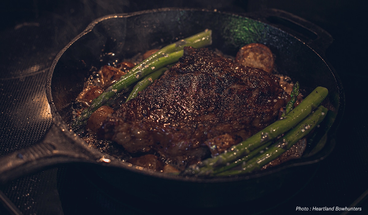 Steak and asparagus in a cast iron skillet.