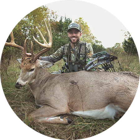 A bowhunter with the whitetail buck he harvested.