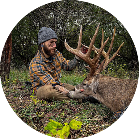 A hunter with the whitetail buck he harvested.