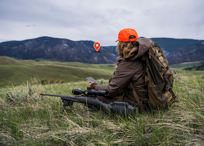 an onX waypoint on a mountain side with a hunter looking towards it