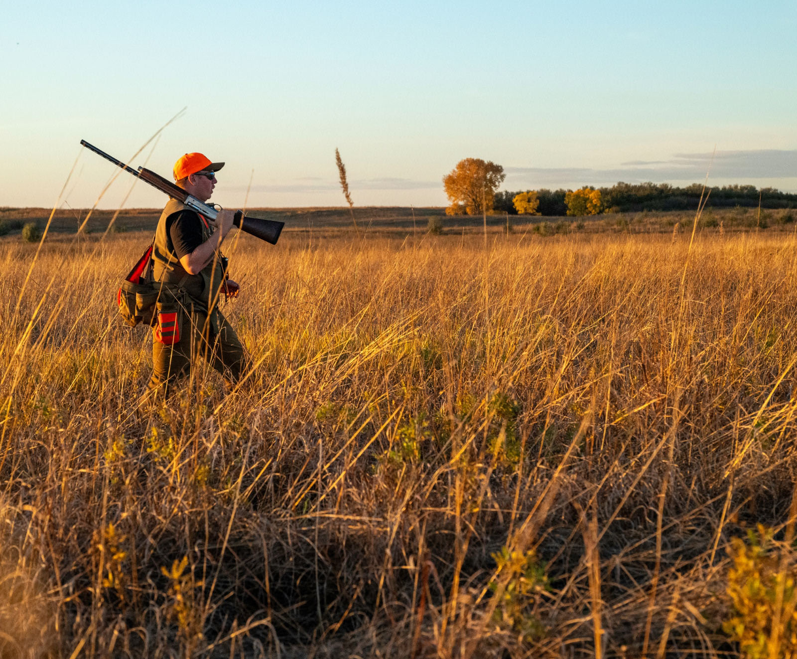 hunter with a rifle in a grassy field
