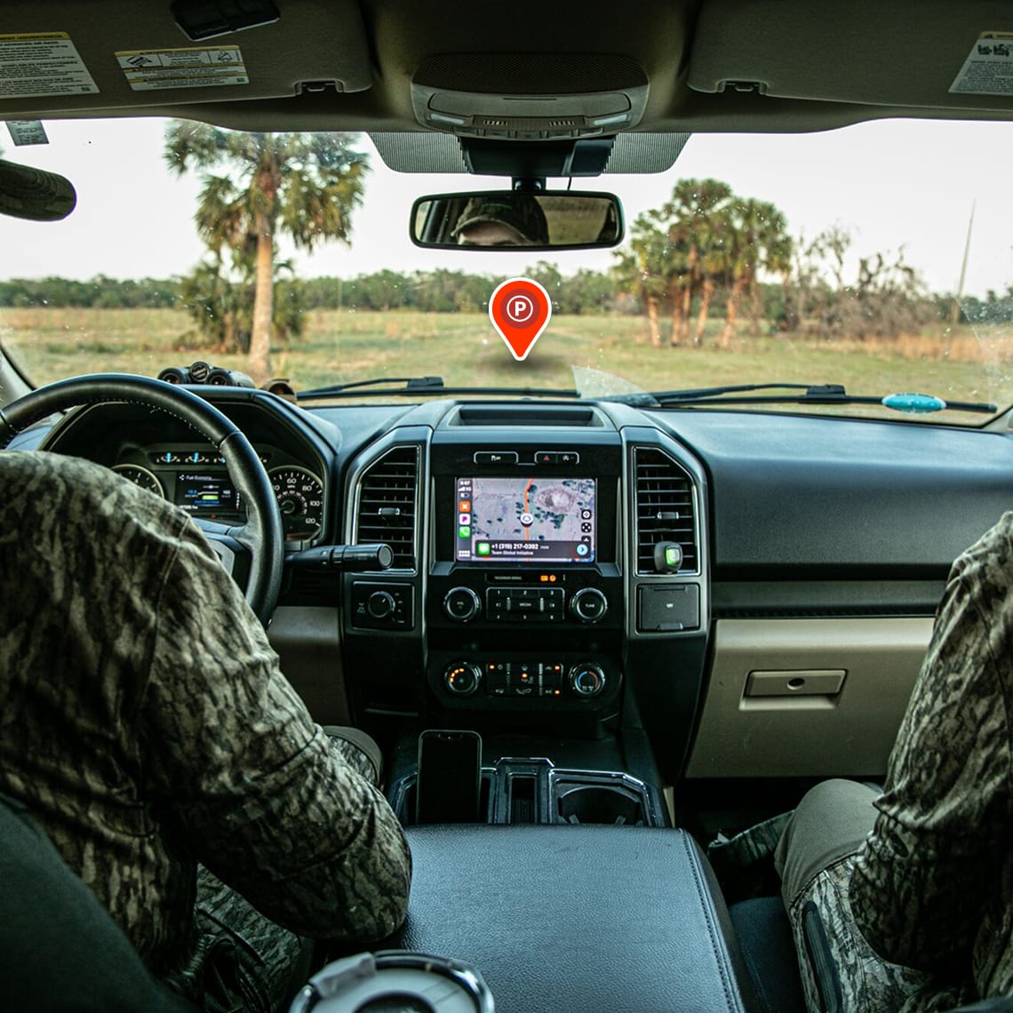 two hunters in a truck with onX Hunt on carplay