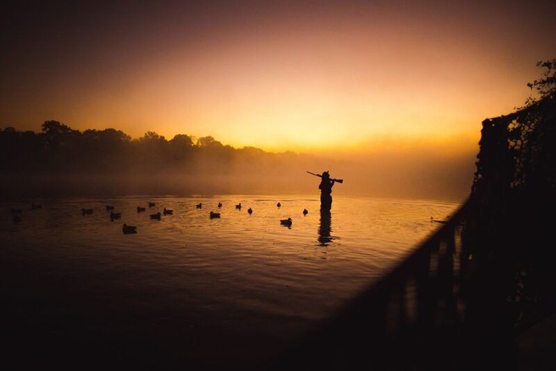 a man shooting a duck in the best duck hunting states