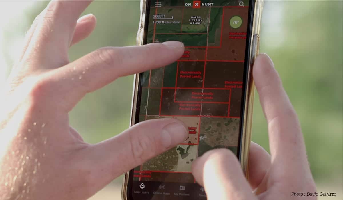 A person uses the onX Hunt App to find property lines. 