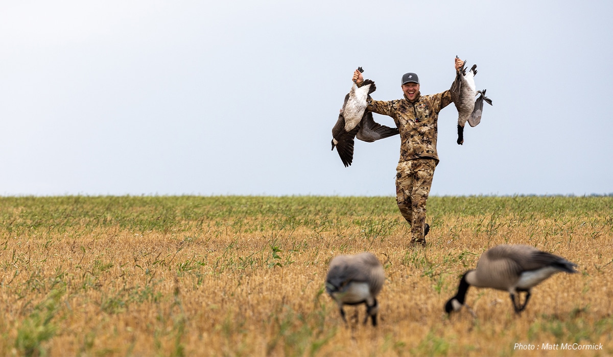 A hunter holds up two Canadian geese they harvested.