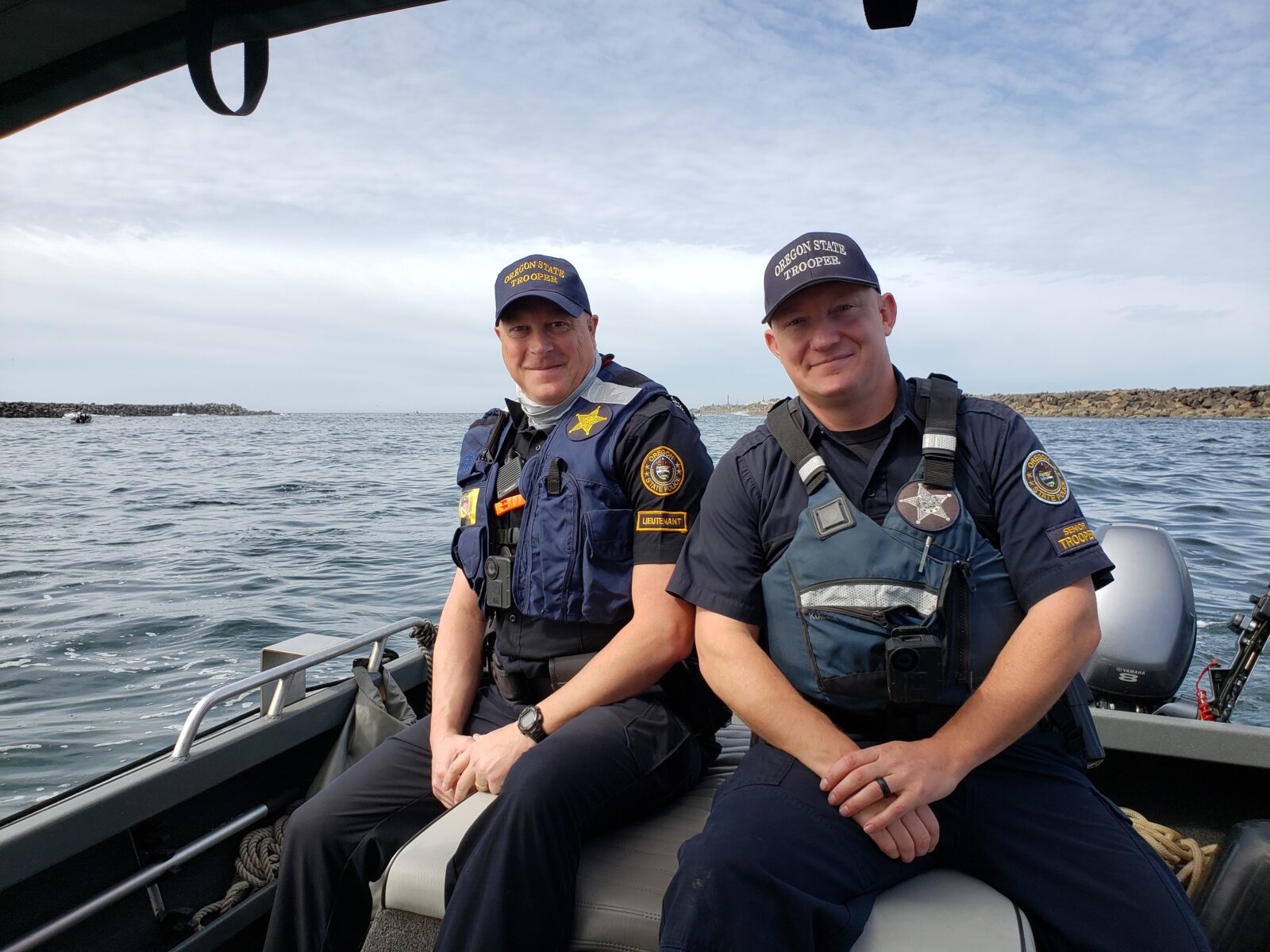 Two Oregon state troopers pose for a photo on a boat.