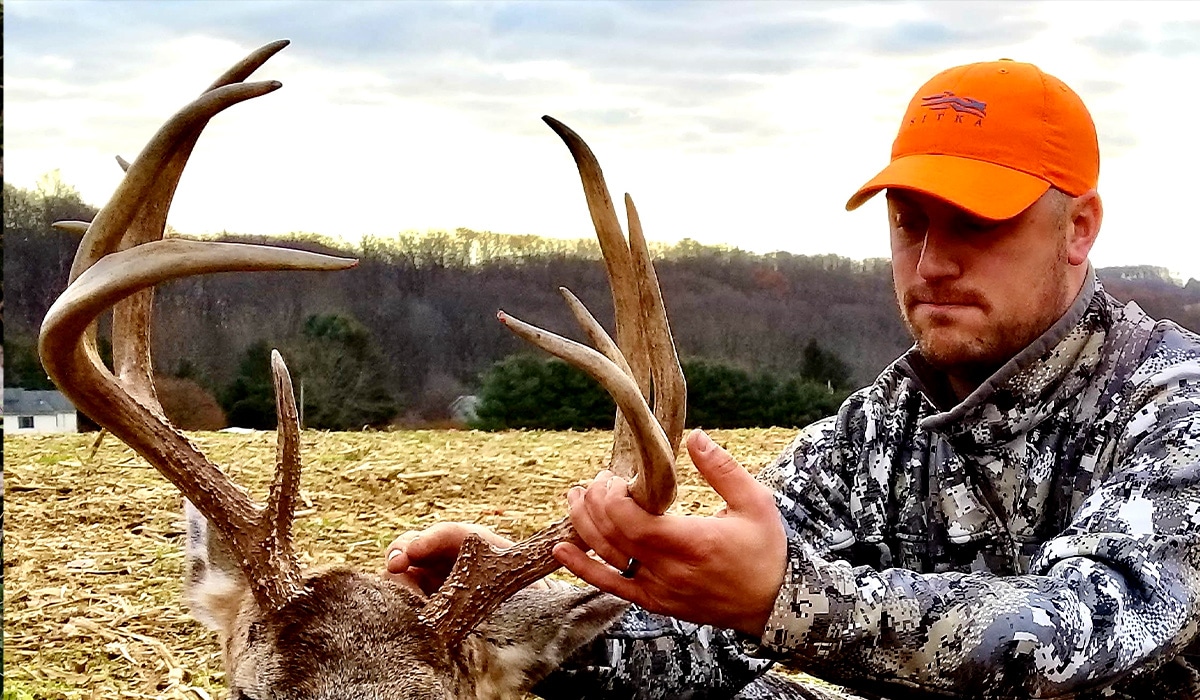 A hunter holds the antlers of a buck he harvested.