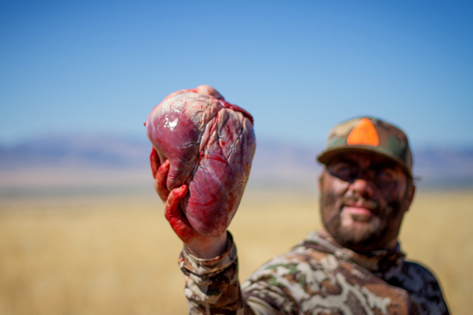 A hunter holds a wild game animal heart.