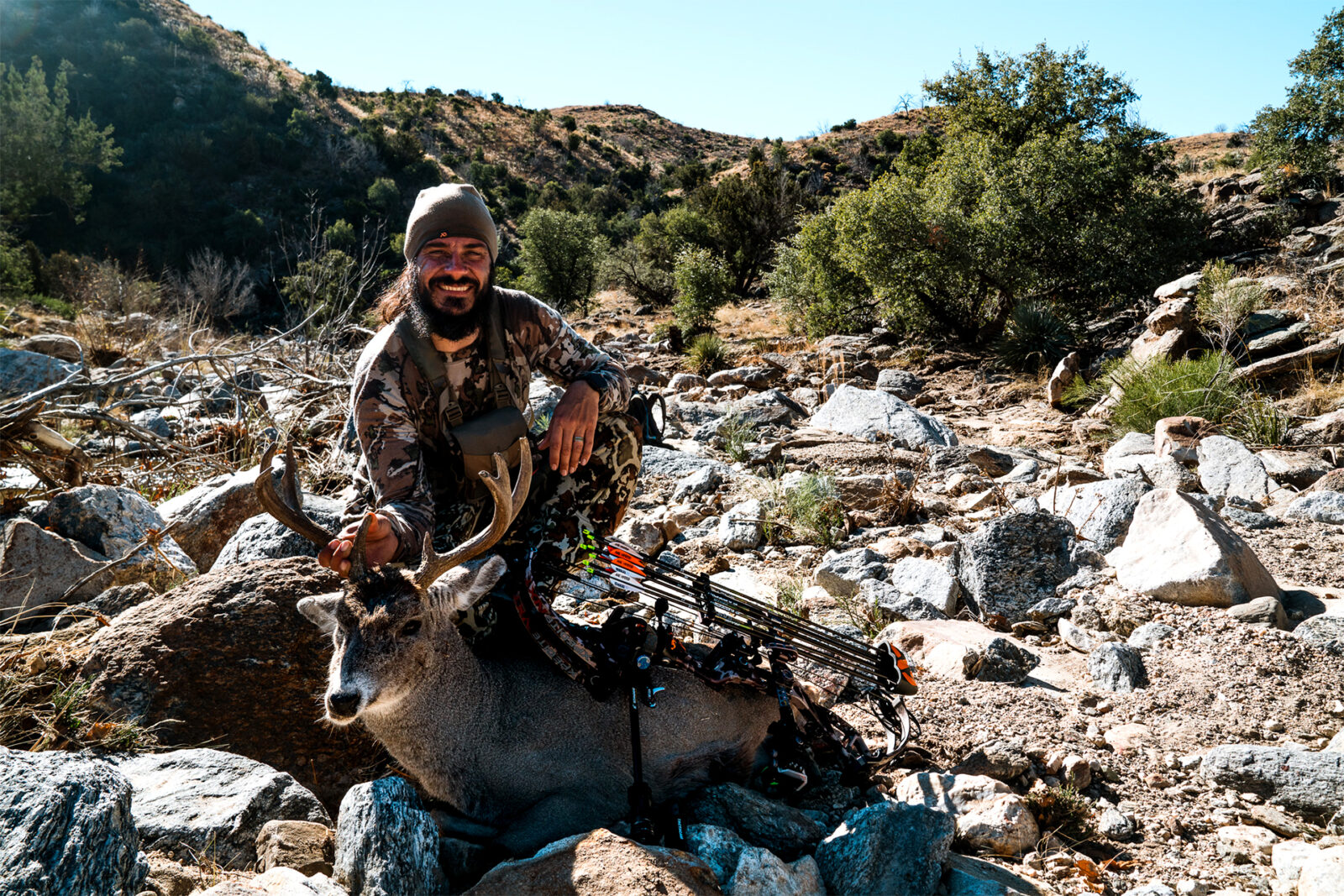 A bowhunter poses with the Coues deer he harvested. 