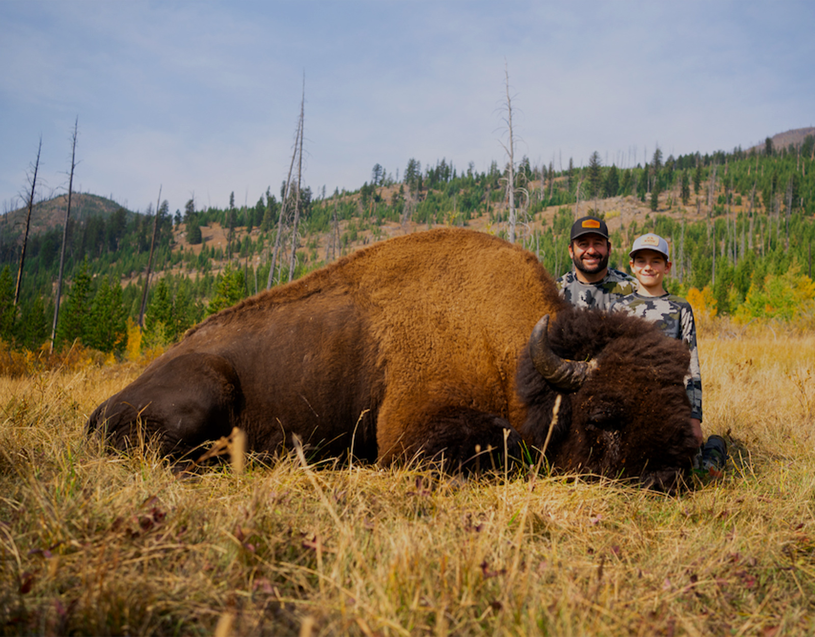 Father and son hunting a bison in Wyoming.