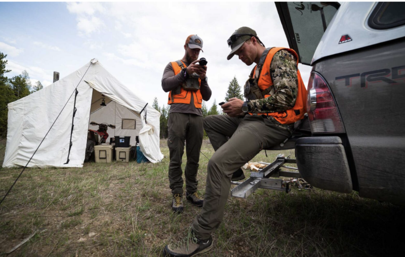 hunters looking at a hunting app or hunting gps in their camp.