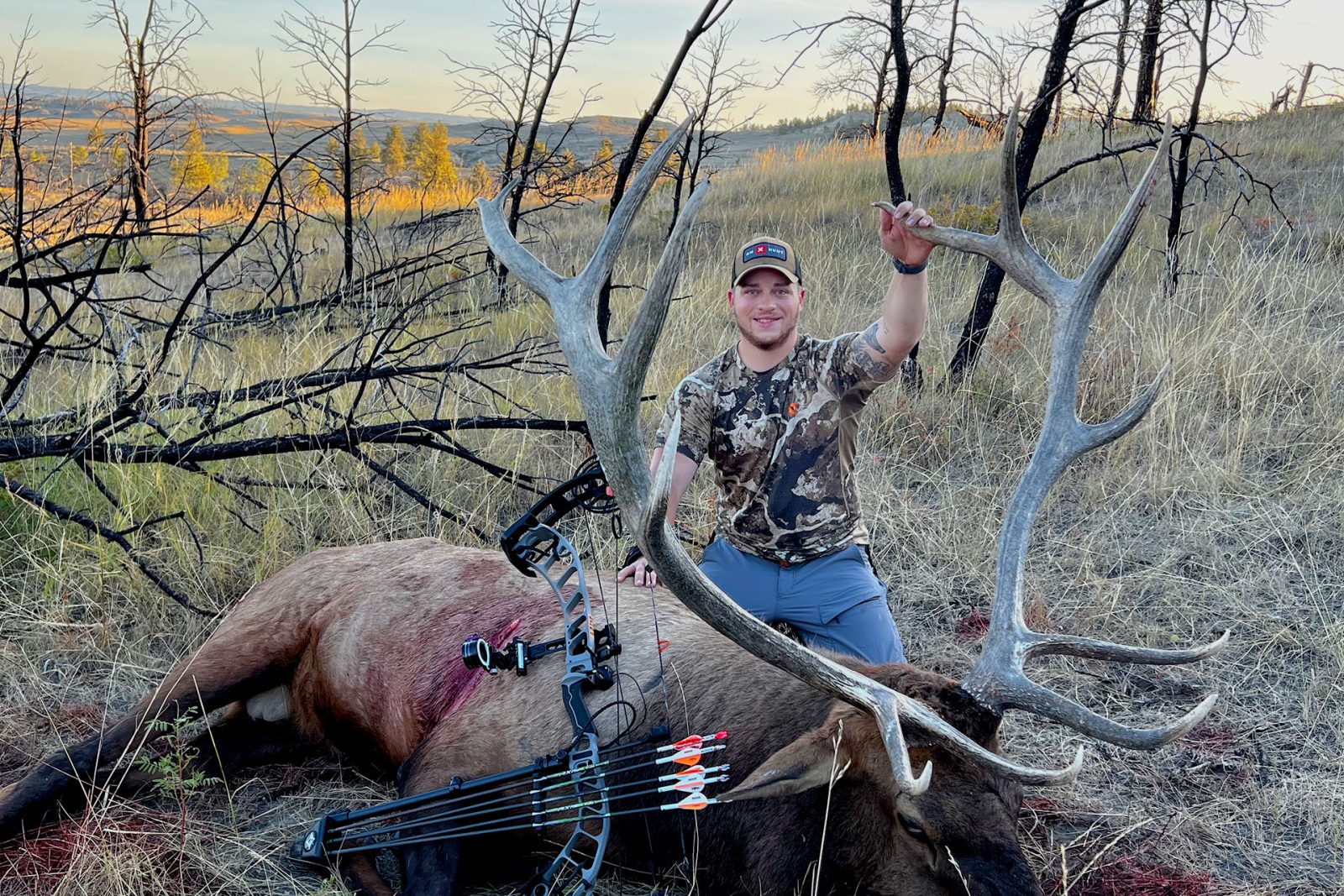 Dylan Dowson from onX Hunt with a bull elk he downed on an archery elk hunt