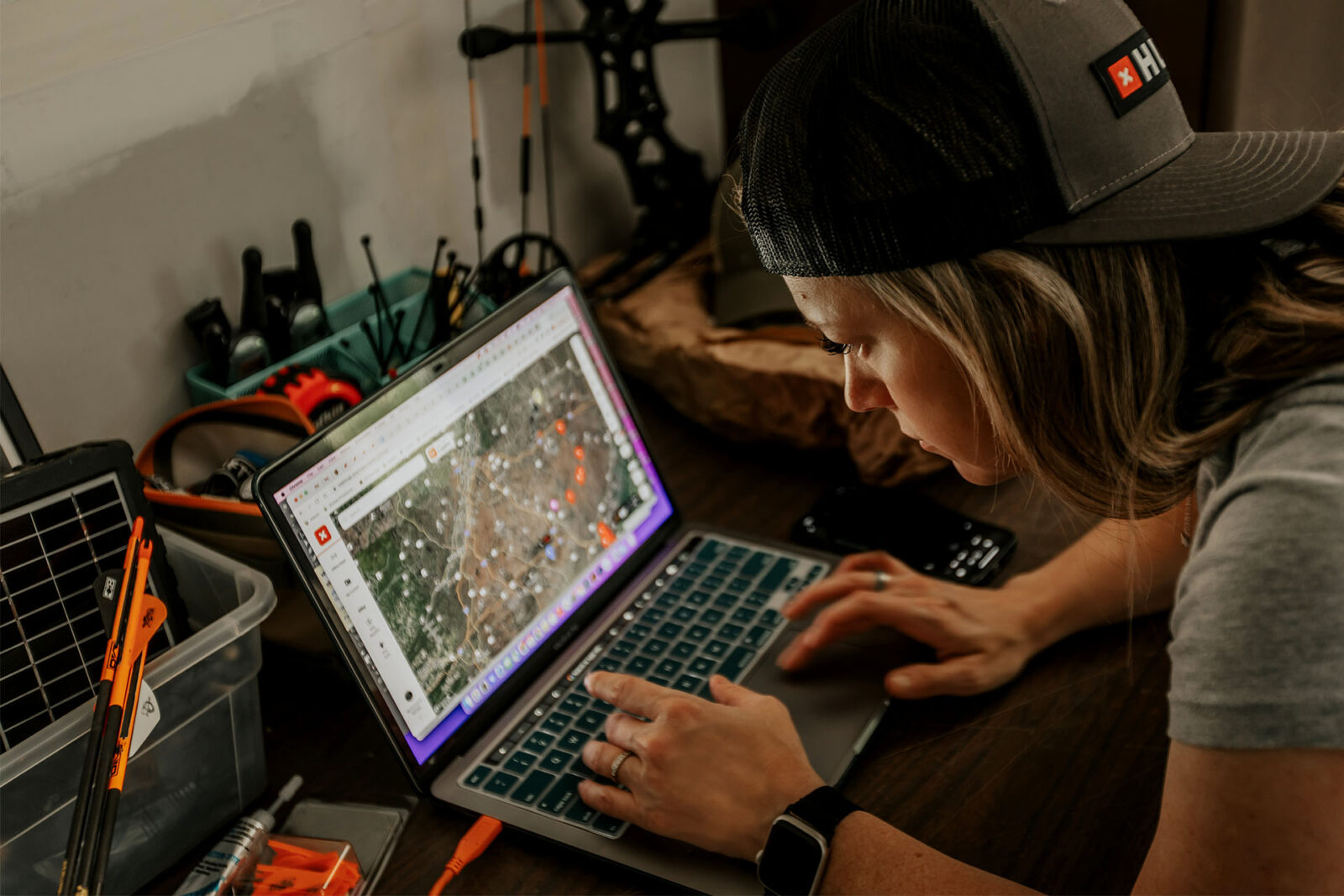 A female hunter uses onX Hunt to e-scout on her laptop. 