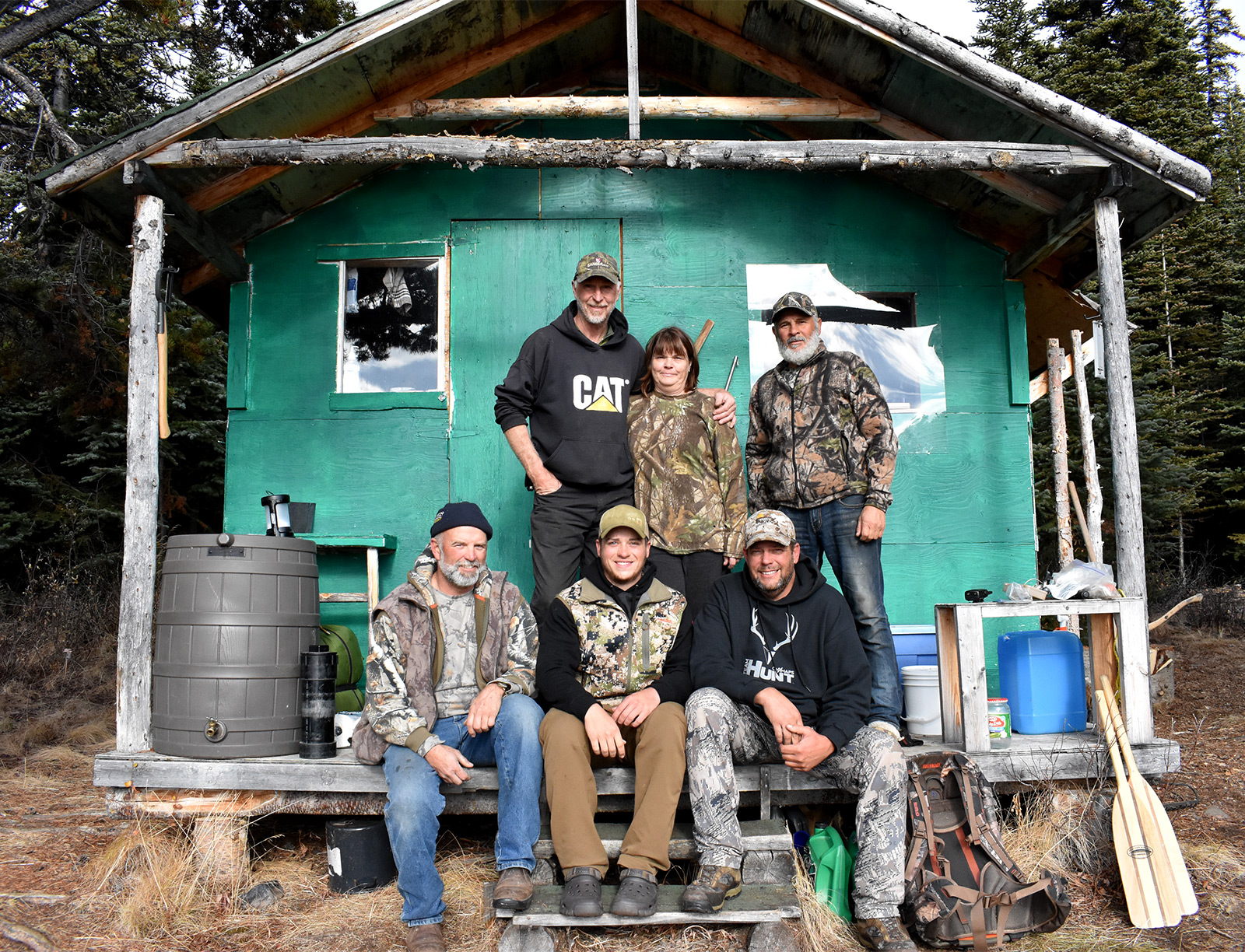 Hunters in Alaska sitting on a porch cabin.