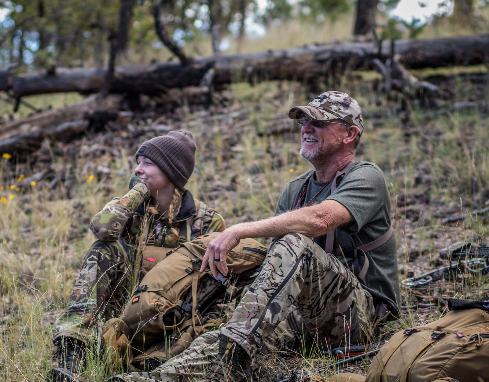 Woman and man in camo hunting in the mountains.