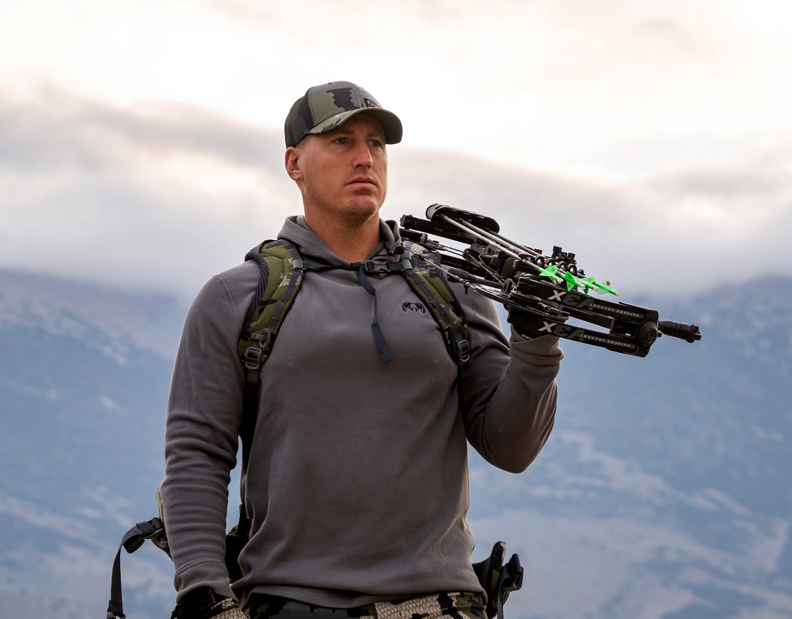 Jeff Althoff standing on a ridge with a crossbow over his shoulder. 