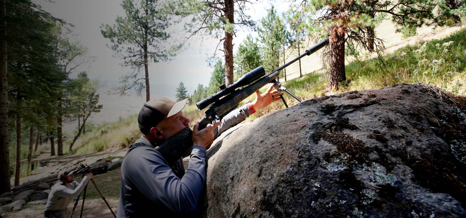hunting shooting with a rifle resting on a rock
