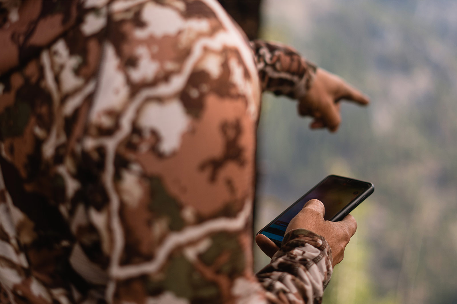 man scouting for hunting with phone