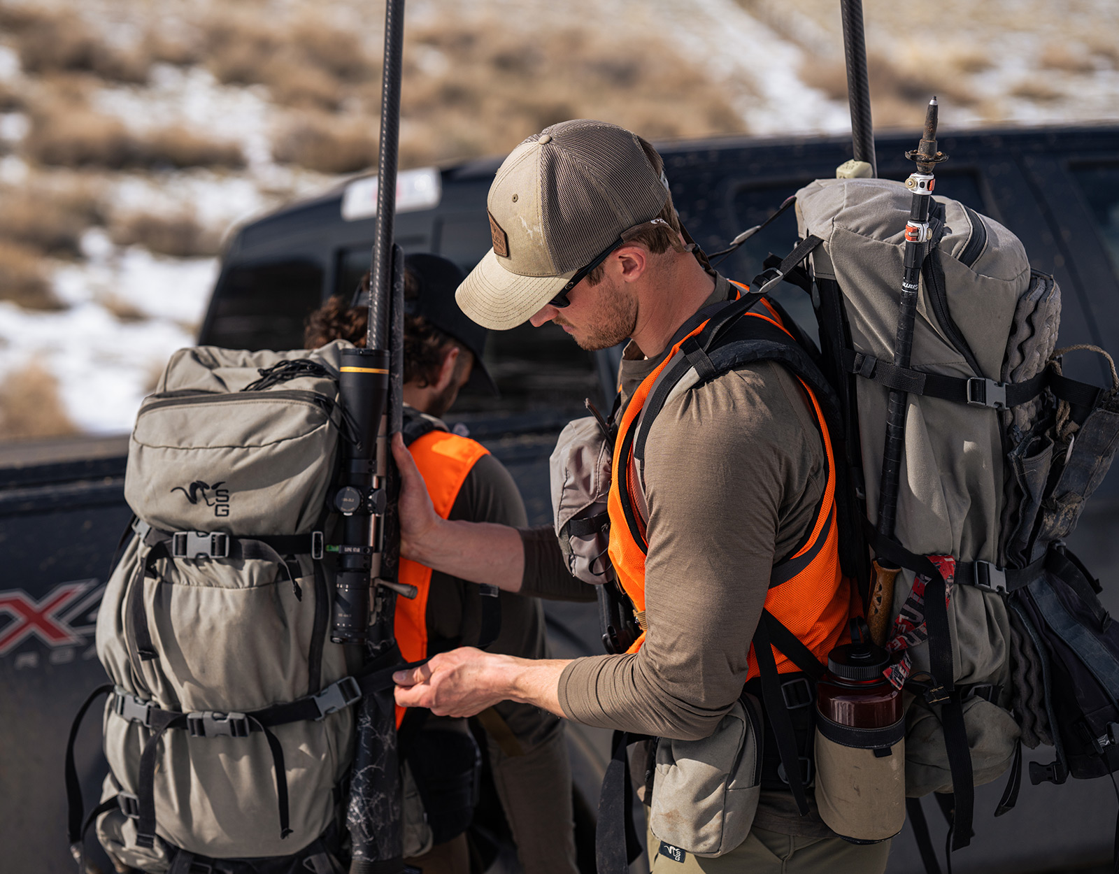 two hunters with hunting backpacks with rifle carriers 