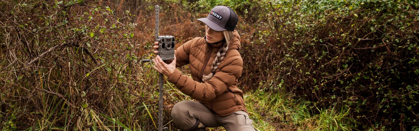 a Hunter setting up a trail cam on a tree