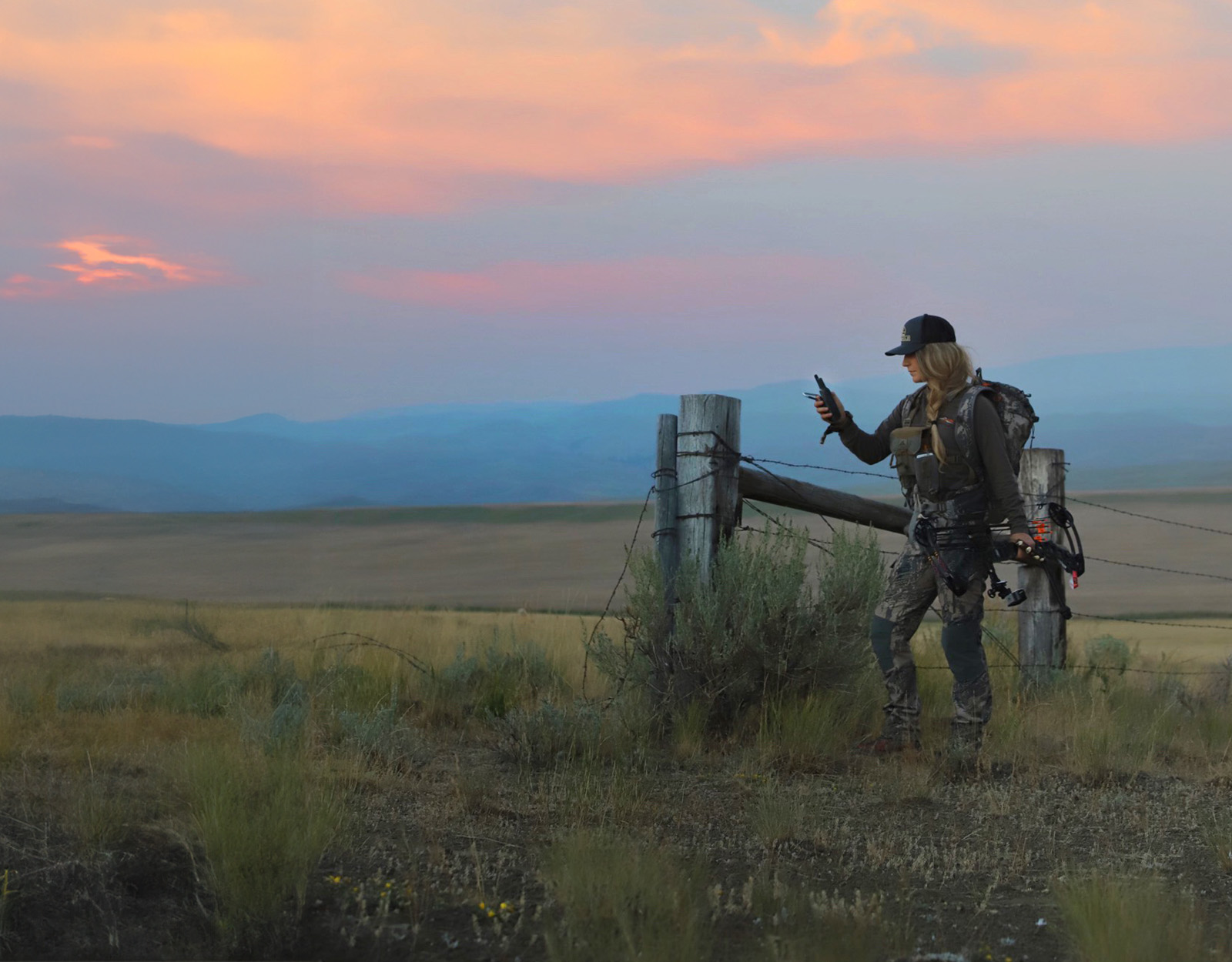 A women bowhunter uses the onX Hunt App in the field.