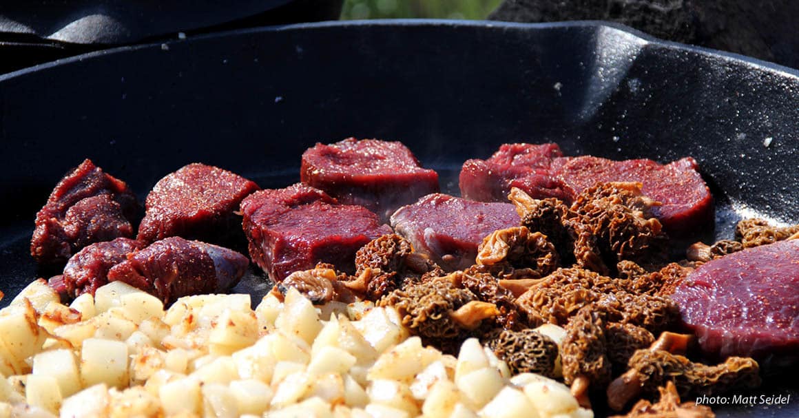 steak cooking in cast iron pan