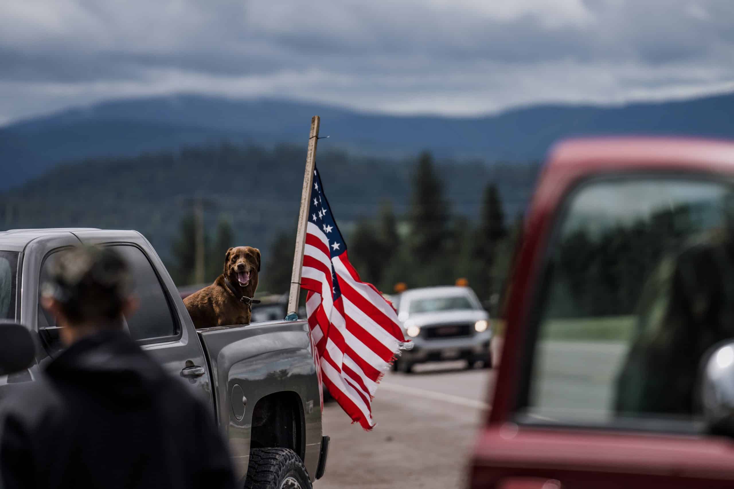The red white and blue waving in the back of a truck. The red white and blue waving in the back of a truck.