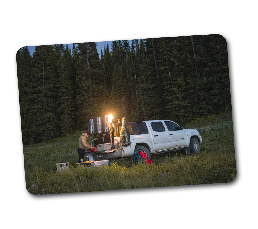 A white truck parked at a trailhead.