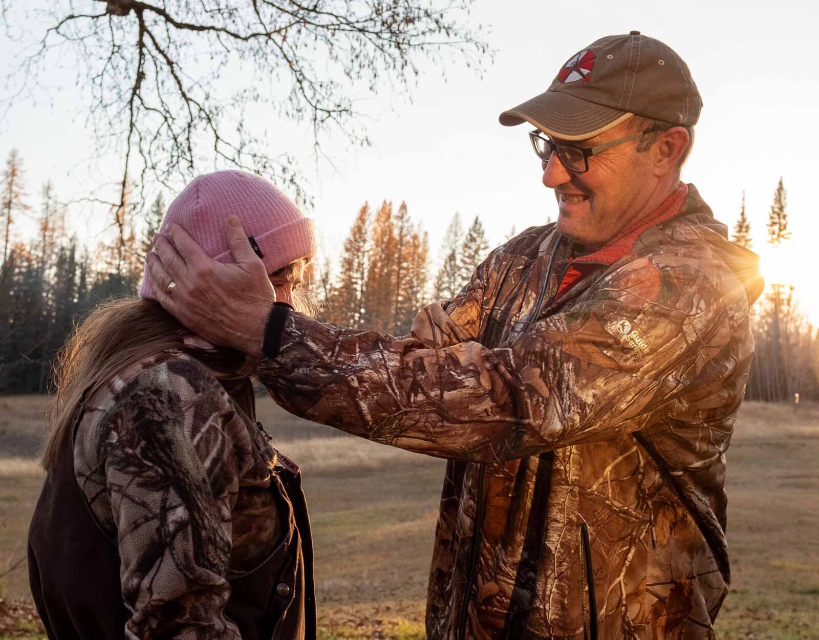 Father and daughter in full hunting camo out in the field. 