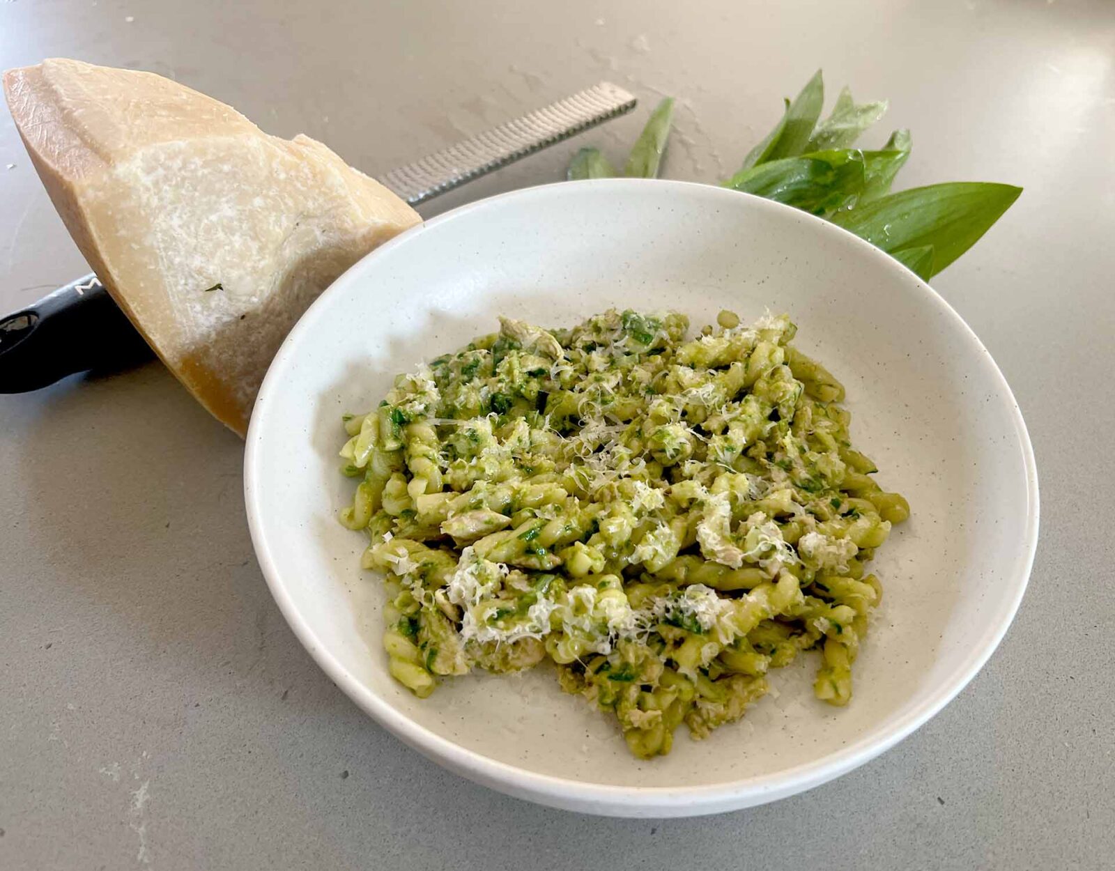 Wild ramps pesto pasta plated in a white bowl.