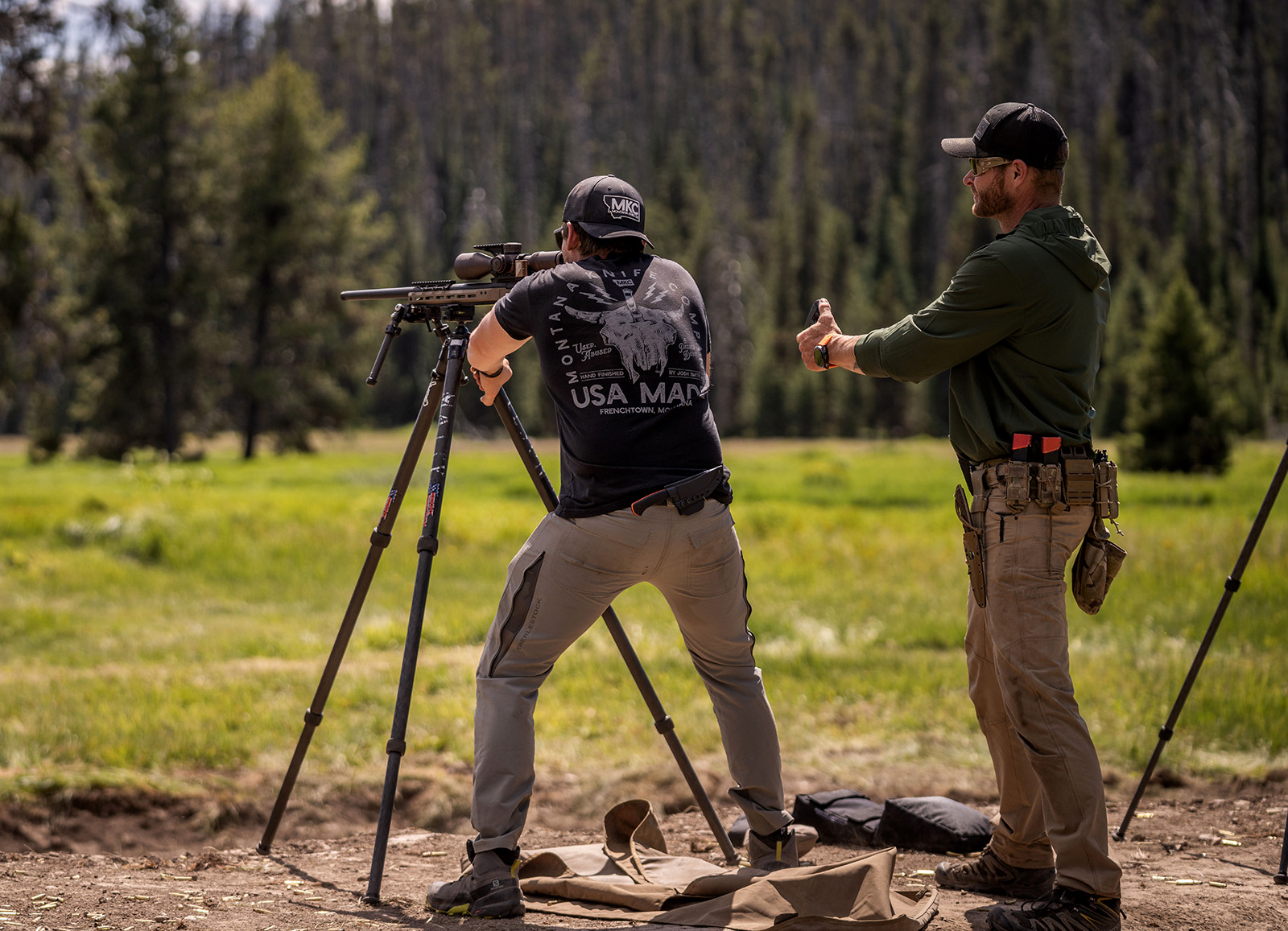 A spotter and a shooter set up for a shot at a long-range shooting range.