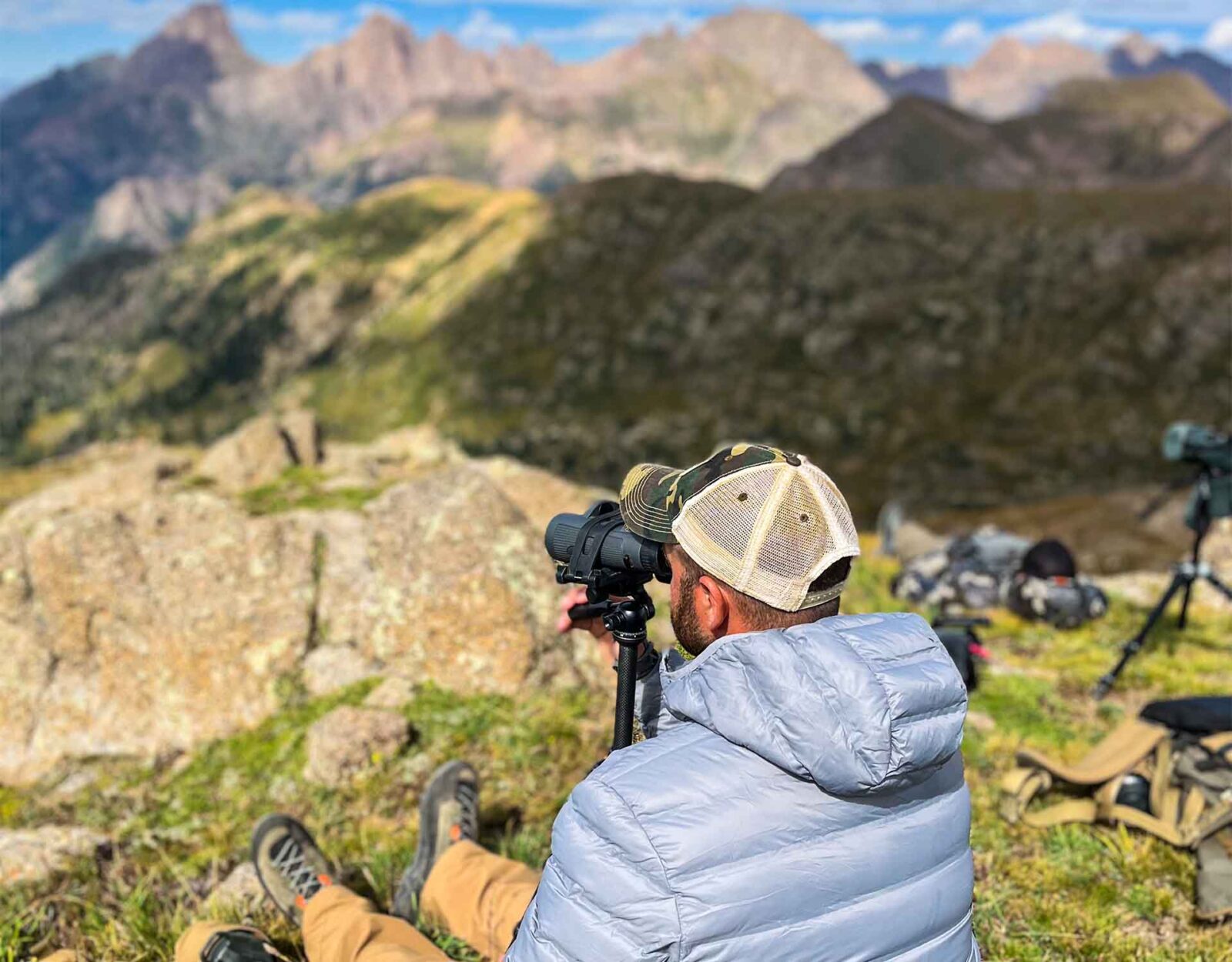 A man glassing for deer in the mountains.