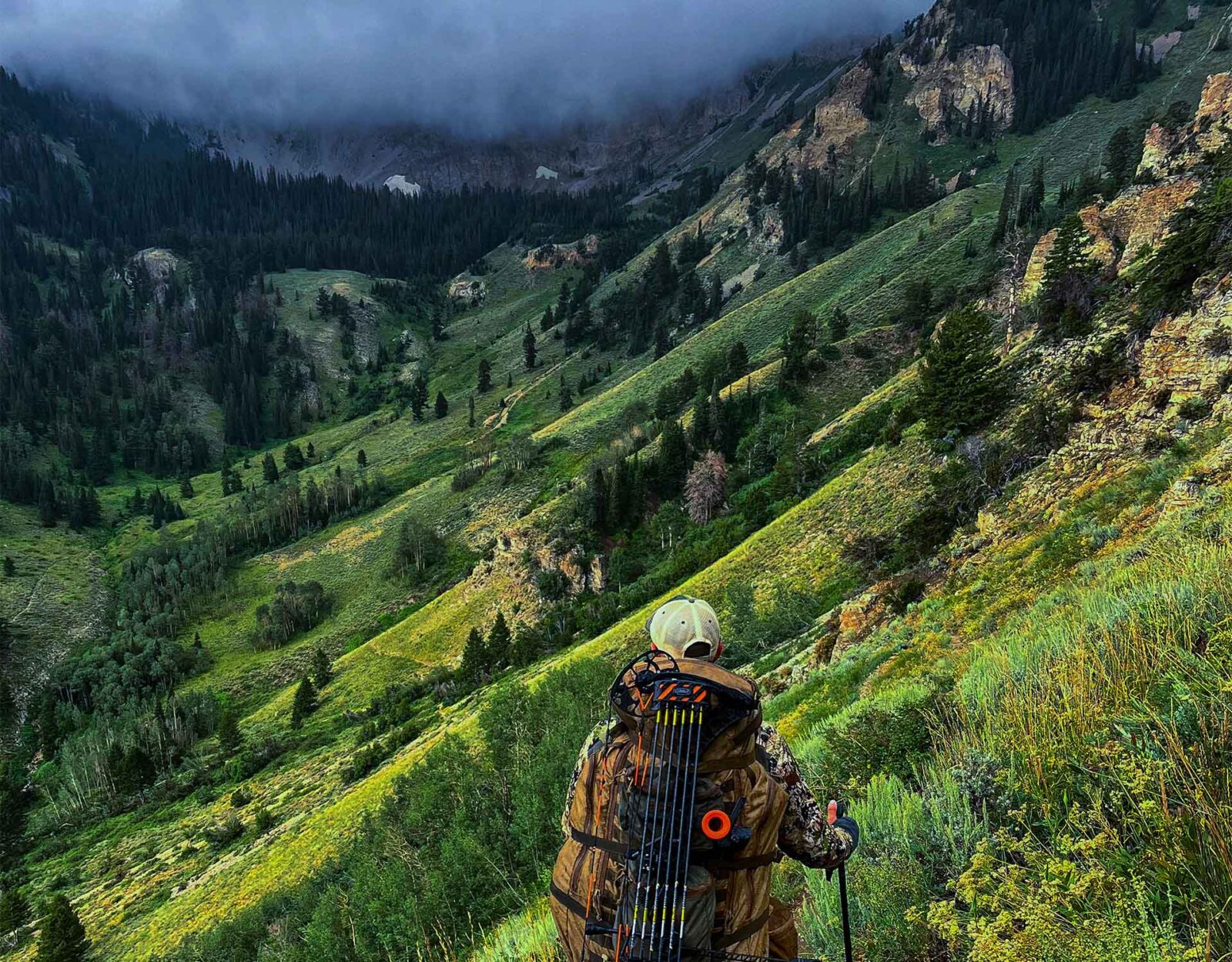 A man hikes in steep terrain.